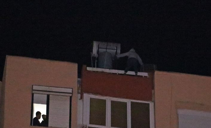 12 katlı apartmanın çatısından aşağı sarkan genç kadını film izler gibi izlediler