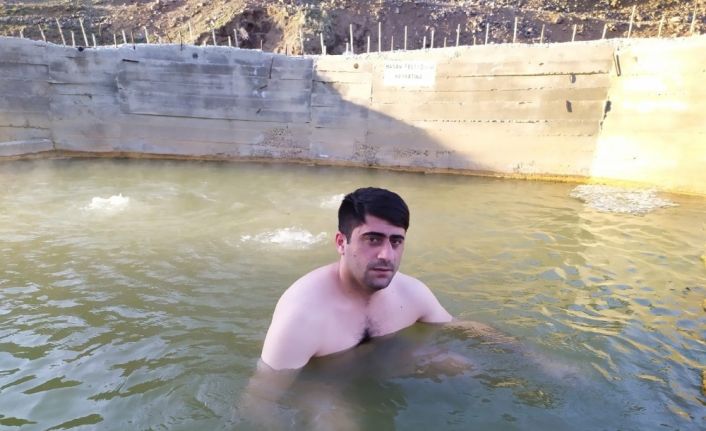 Köyüne dönen genç adam, jeotermal suya girerek kendini koruyor