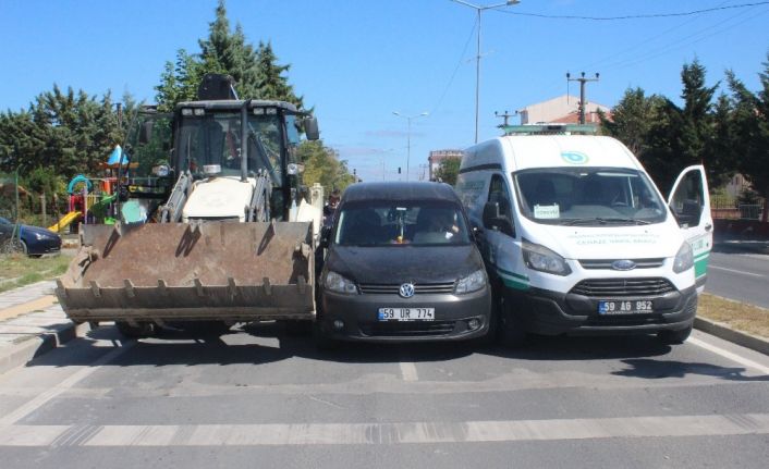 Otomobil, kırmızı ışıkta bekleyen iş makinası ve cenaze aracının arasından geçmeye çalışırken sıkıştı