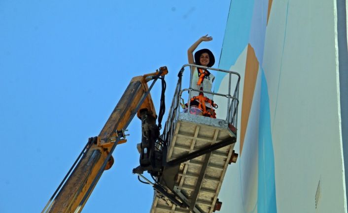 Kafasını kaldırıp vincin tepesinde elinde fırçayla görenler gözlerini alamıyor