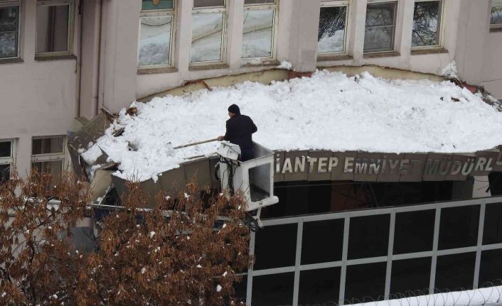Emniyet müdürlüğünün kapı girişi çatısına düşen kar kütleleri vinç yardımıyla temizleniyor