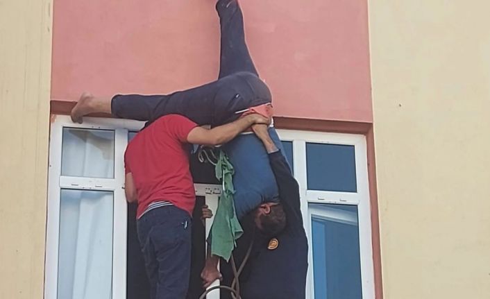 Evine çatıdan sarkıp pencereden girmek istedi, halat kısa gelince asılı kaldı