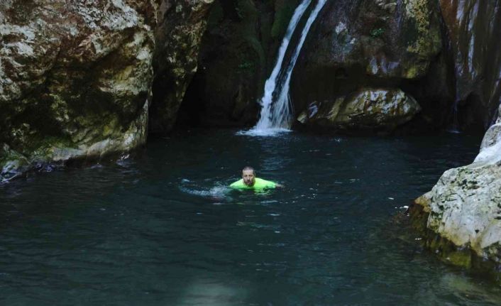 Doğa harikası şelaleleri tanıtmak için soğuk havaya aldırış etmeden buz gibi suda yüzdü