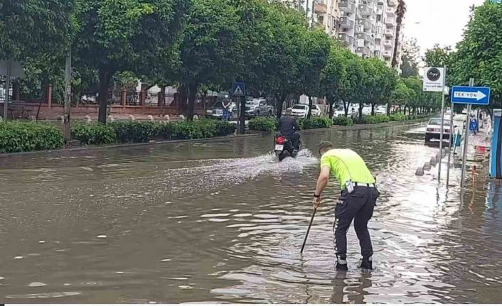 Polisten örnek davranış: Su dolu caddede tıkanan rögarı açtı