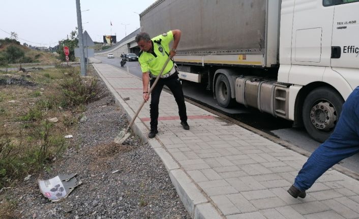 Tırdan yola saçılan yakıta trafik polisi kürekle kum atarak önlem aldı