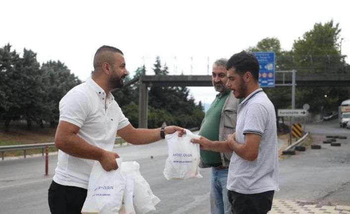 Servis bekleyen işçilere poğaça dağıtılıyor