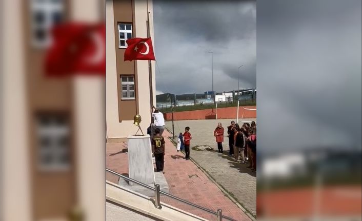 Okul önünde direğe dolanan bayrağı tırmanarak çözdü