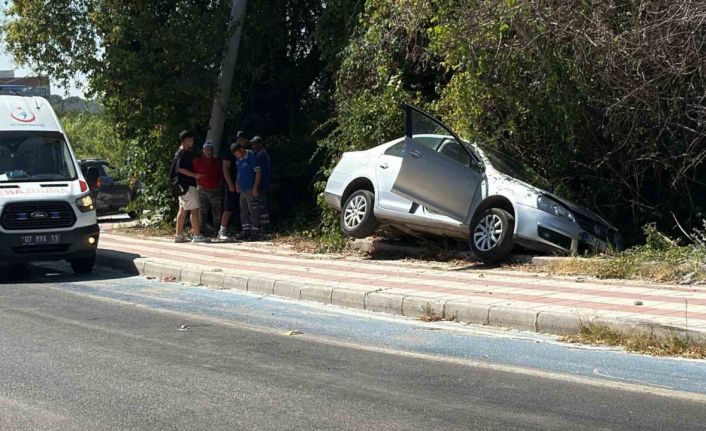 Kaldırıma çıkıp asılı kalan otomobildekiler kazayı burnu bile kanamadan atlattı