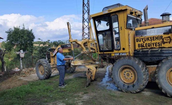 Muhtar, yol çalışması yapan iş makinesini kendi elleriyle yıkadı