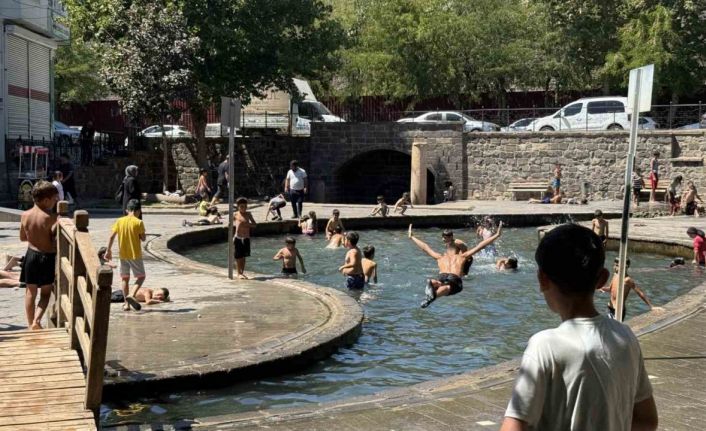 Sıcak havada kavrulan çocuklar, süs havuzunda serinliyor