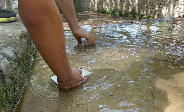 Sıcaklığın 45 dereceyi bulmasıyla telefonlarını suda soğuttular