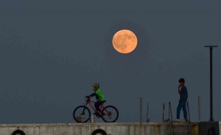 Dolunay ile insanların siluetleri aynı karede
