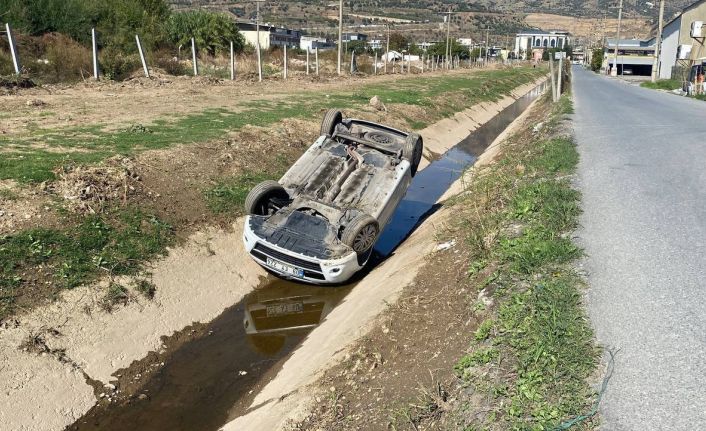 Kanala uçup ters dönen araçtan burunları bile kanamadan çıktılar