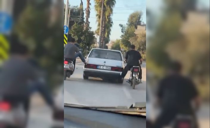 Motosikletliler, yolda kalan otomobili ayaklarıyla ittirdi