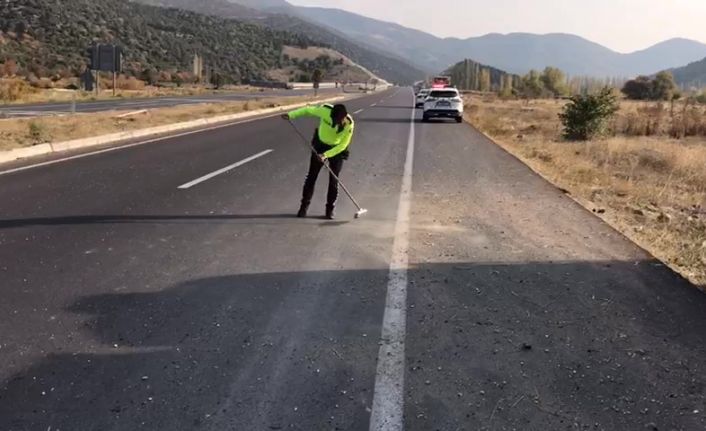 Trafik polisi cam kırıkları ve taş dökülen yolu fırçayla temizledi