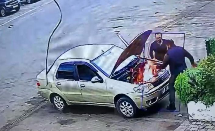 Alev alan otomobili üfleyerek söndürmeye çalıştı: O anlar kamerada