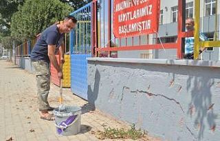 Okul müdürü elinde fırçayla okulu boyuyor