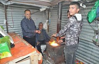 Soğuk havaya karşı soba yakarak müşteri bekliyorlar