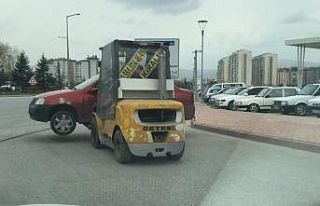 Forklift ile caddede otomobil taşıdı
