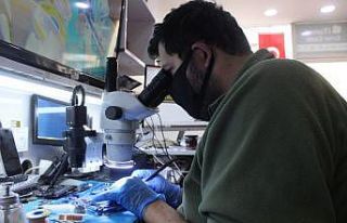 Maske ve eldivenle telefon tamir ediyor, dezenfekte...
