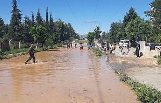 Çocukların patlayan borudan akan suda çamurla oyunu