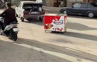 Arabasına bağladığı dondurma dolabını çekmeye...
