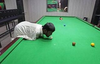Kolları olmayan adam çenesiyle bilardo oynayarak...