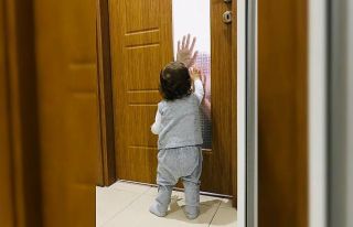 Koronalı baba çocuğunu camın arkasından seviyor