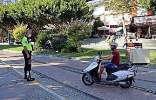 Tramvay yolu ve kaldırımı kestirme yol seçen motosiklet...