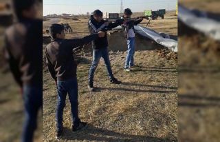 Üç çocuğuna tüfek ve silahla atış talimi yaptırdı