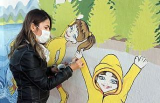 Şengül öğretmen çocuklar için duvarları renklendiriyor