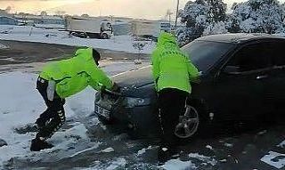 Trafik polisleri elleriyle kar küreyerek yolda kalan...