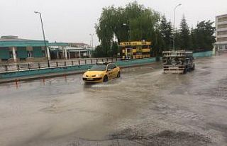 Sağanak yağmurda suyla dolan altgeçitte otomobil...