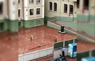 Yağmura aldırmadan İstiklal Marşı okuyan miniklerden...