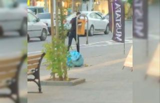 Kaldırımdaki çöp kutusunu söküp götüren genç...