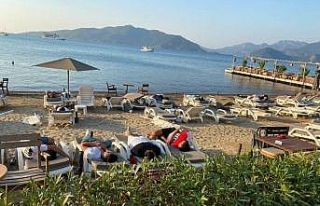 Uyarıları dikkate almayan turistler sahilde uyuyor