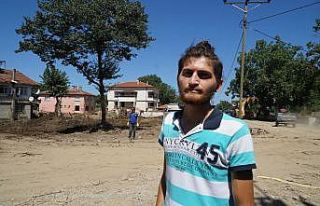 Boyunu aşan sel sularına rağmen sörf tahtasıyla...