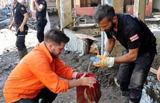 Çamur içinden çıkan bayrağı temizleyip en yüksek...