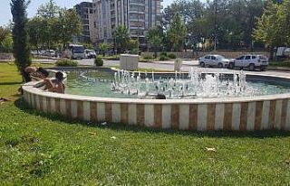 Sıcakta bunalan çocuklar süs havuzunda serinliyor