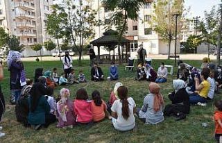 Başkan Beyoğlu çimlerin üzerinde bağdaş kurup...