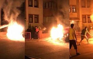 Mahalle halkı alev alan aracı söndürmek için...