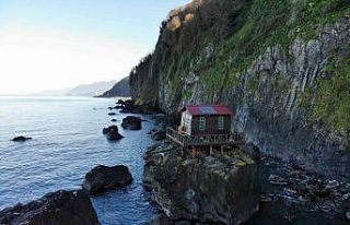 Deniz kıyısındaki kayanın üzerine yapılan baraka...