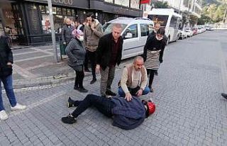 Kazada yaralanarak yerde yatan adama vatandaşlardan...