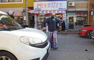 Palyaço hareket halindeki araçların arasında gösteri...