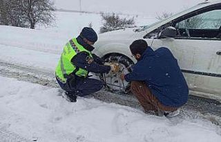 Yolda kalan araçlara zincir takan güvenlik güçlerinden...