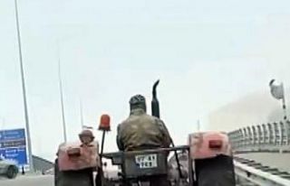 Traktör arkasındaki sabanla asfaltı çizerek karayolunda...