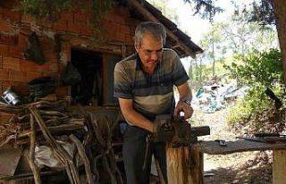 Evinin bahçesinde ahşap kulübede elleriyle yapıyor,...