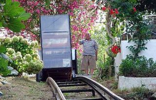 Yokuşun başındaki evine kurduğu raylı sistemle...