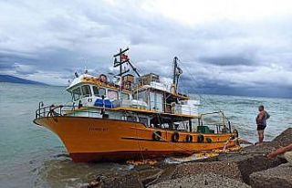 Kayalıklara oturan teknedeki balıkçılar denize...