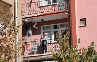 Çatıda yatarak sıva yapan usta bu kez de balkon...
